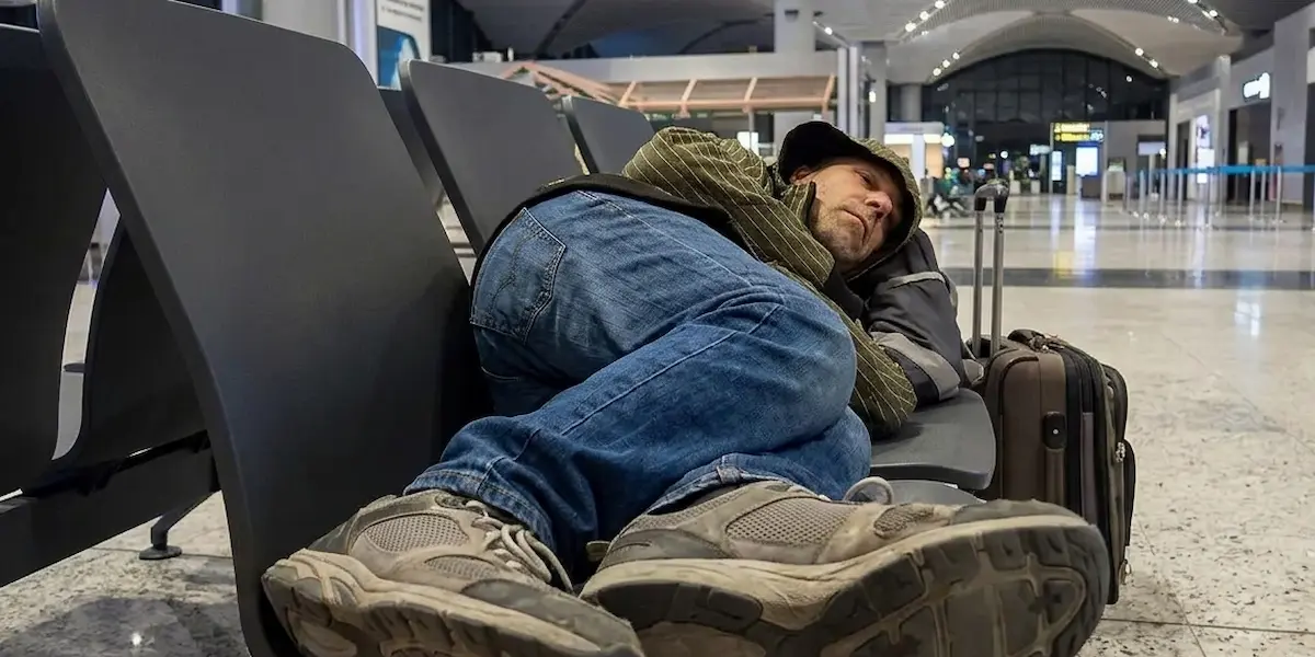 Traveler resting in a themed gate lounge chair inside Taiwan Taoyuan International Airport at night