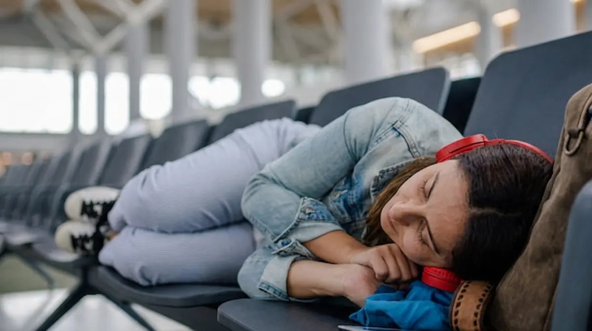 Traveler resting at a quiet gate area inside airport at night