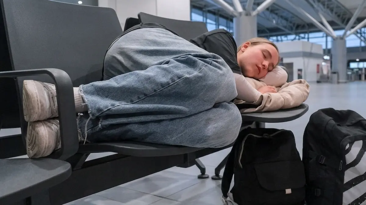 Traveler resting at a quiet gate area inside Al Najaf International Airport at night