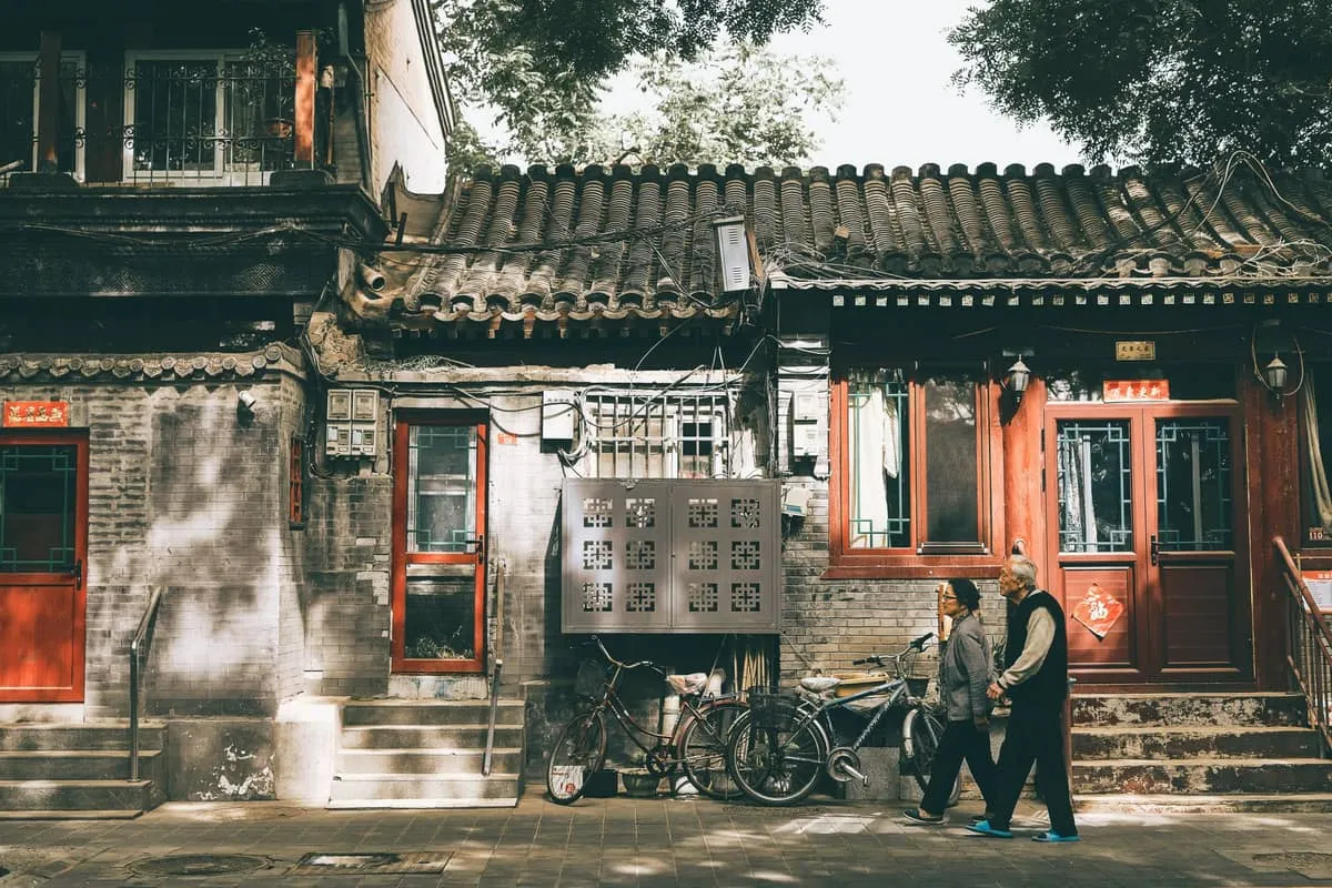 Traditional grey-brick hutong lane with courtyard house doors in Beijing's old city