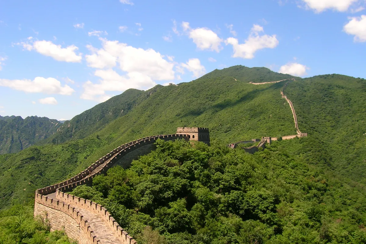 Great Wall of China winding over green mountains at the Mutianyu section near Beijing