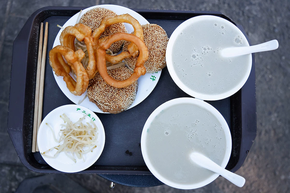 Traditional Beijing breakfast of douzhi with crispy jiaoquan fried dough rings