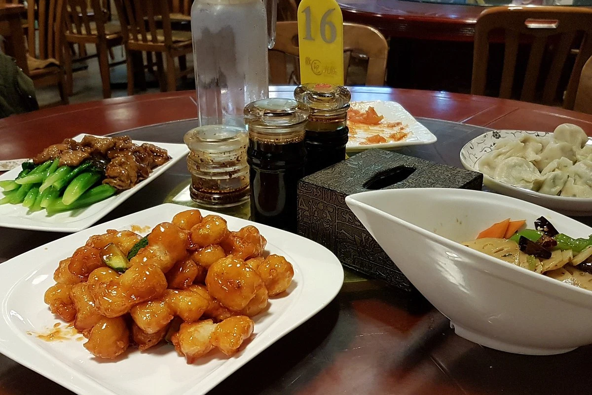 Steaming plate of handmade dumplings served in a traditional Beijing hutong restaurant