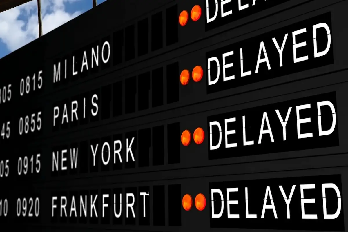 Airport departures board showing delayed flights