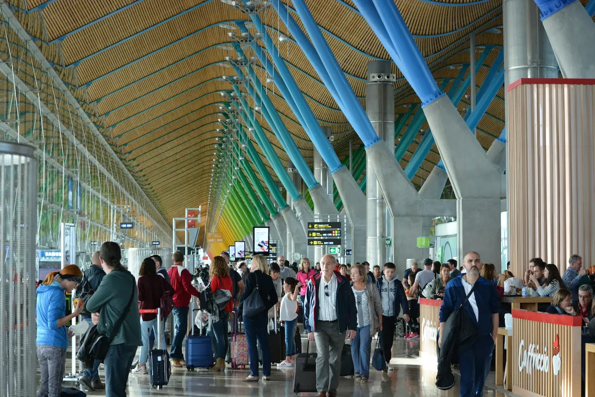 Long security queue stretching through a crowded airport terminal