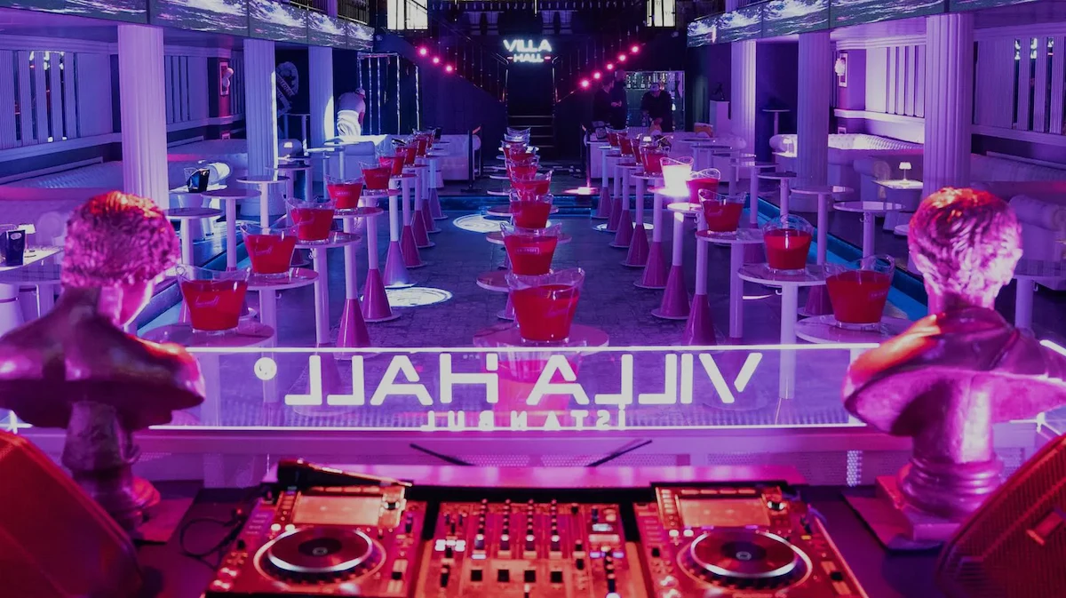 Villa Hall interior with DJ set, statues and tables